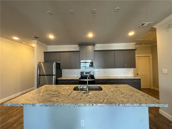 a kitchen with kitchen island a sink and a refrigerator