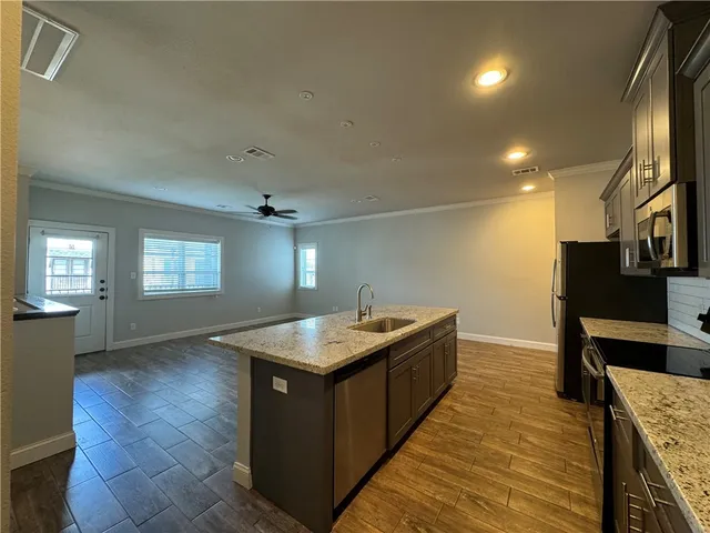 a kitchen with sink stove and refrigerator