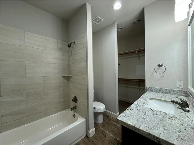 a bathroom with a granite countertop sink toilet and shower