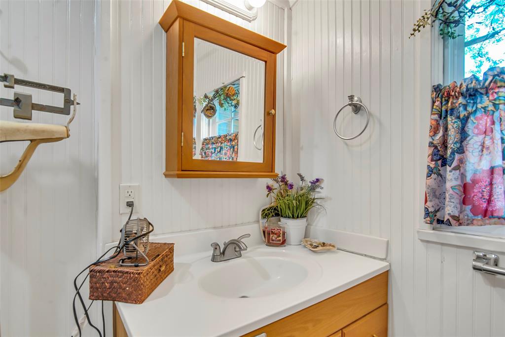 182 Douglas Street Van Alstyne, TX 75495 - Photo 13 of 23 a bathroom with a sink and a mirror