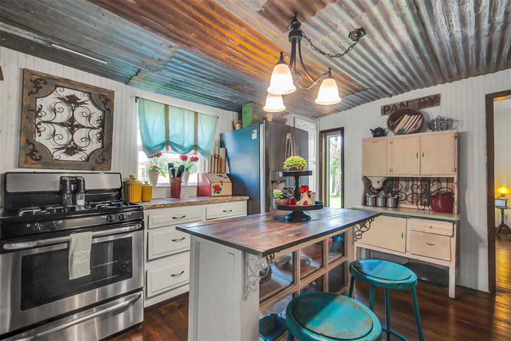 182 Douglas Street Van Alstyne, TX 75495 - Photo 21 of 23 a kitchen with stainless steel appliances a stove a sink dishwasher and cabinets with wooden floor
