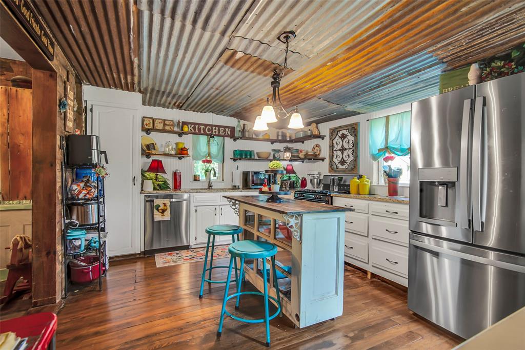 182 Douglas Street Van Alstyne, TX 75495 - Photo 23 of 23 a kitchen with stainless steel appliances granite countertop a refrigerator a stove and white cabinets with wooden floor