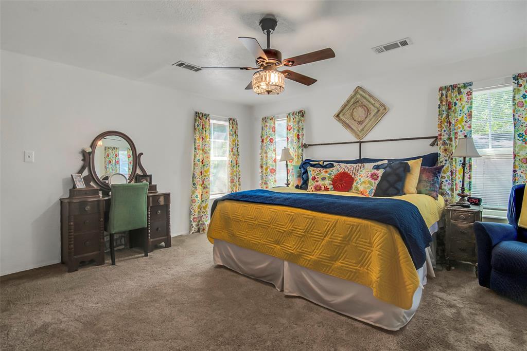 182 Douglas Street Van Alstyne, TX 75495 - Photo 10 of 23 a bed room with a bed and a painting on the wall