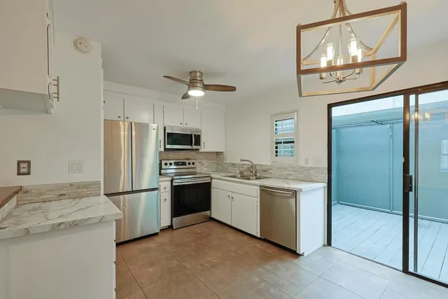 a kitchen with stainless steel appliances granite countertop a refrigerator a stove a sink and a refrigerator