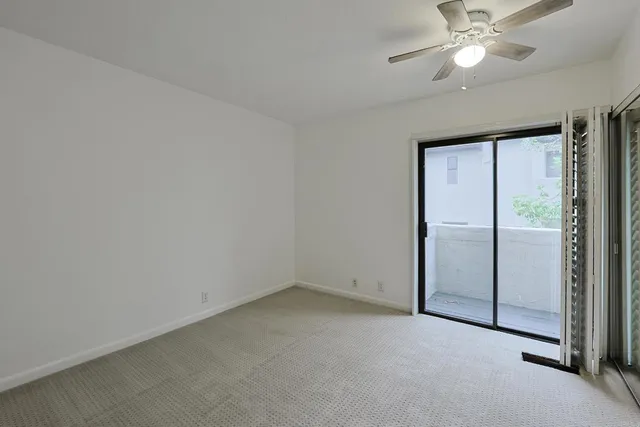 an empty room with closet and a chandelier fan