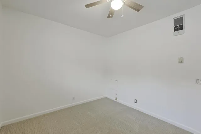 an empty room with a chandelier fan