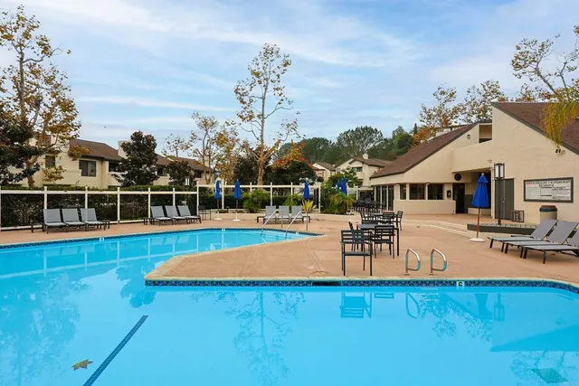 a view of a house with pool and chairs