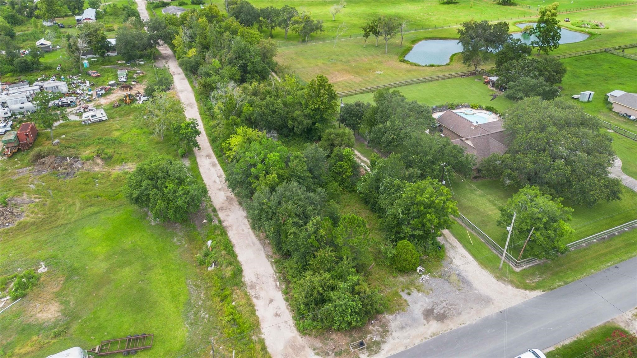 15601 Fir Road Santa Fe, TX 77517 - Photo 3 of 9 a view of a green yard with large trees