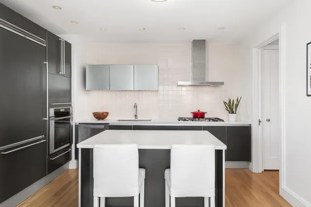 a kitchen with a sink a refrigerator and cabinets