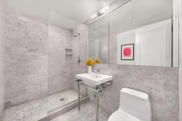 a bathroom with a sink a toilet and shower