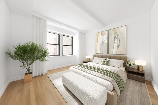 a bedroom with a large bed and a potted plant