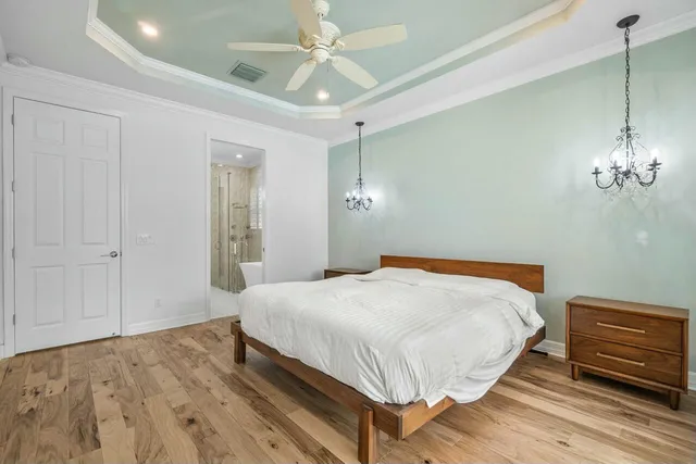 a bedroom with a bed and a chandelier