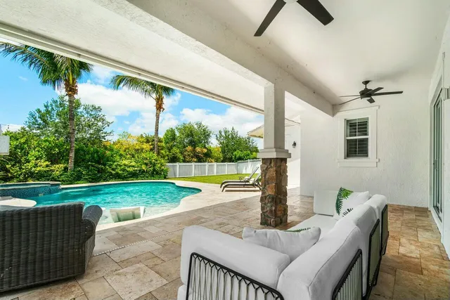 a view of a patio with a table chairs and a swimming pool