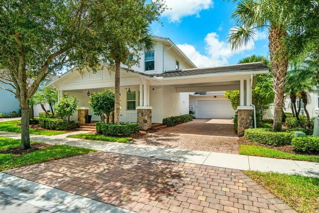 a front view of a house with a yard and potted plants