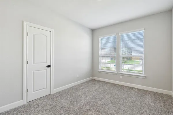 an empty room with windows and closet
