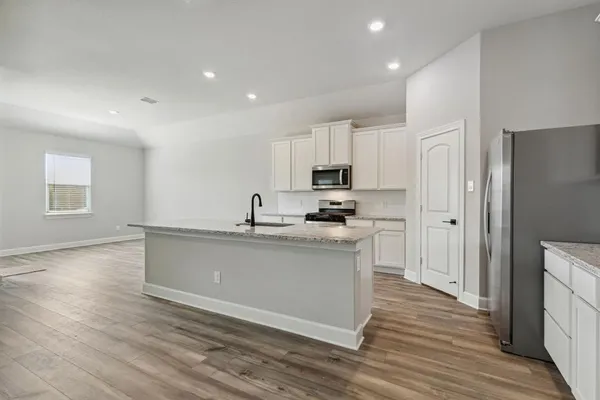 a kitchen with stainless steel appliances granite countertop a sink a stove a refrigerator and cabinets