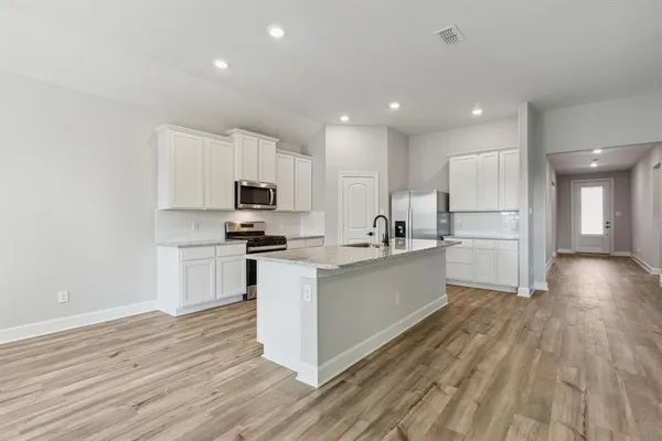 a kitchen with white cabinets and stainless steel appliances