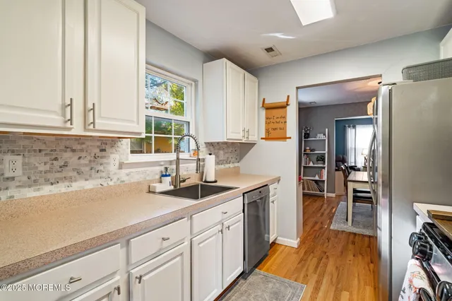 a kitchen with stainless steel appliances granite countertop a refrigerator stove and sink