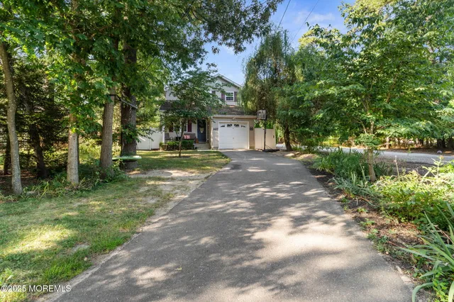 a front view of a house with a yard and trees