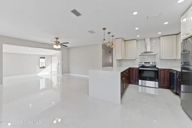a kitchen with granite countertop a refrigerator and a stove top oven