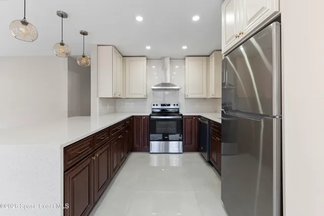a kitchen with kitchen island granite countertop a refrigerator stove top oven and sink