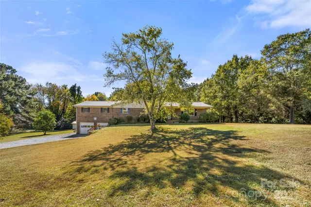 a big yard with trees in front of it