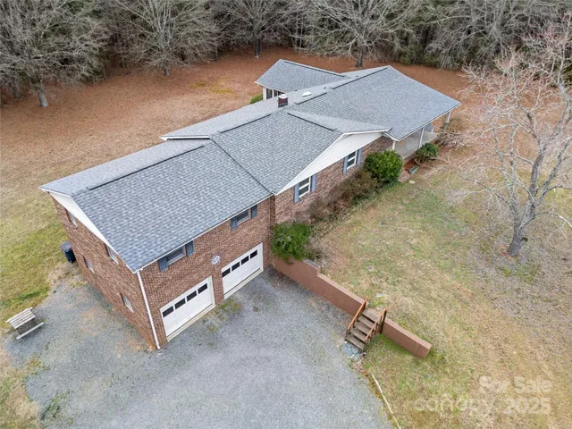 an aerial view of a house with a yard and a terrace