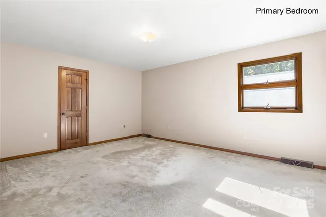 a bedroom with a bed chandelier and a window