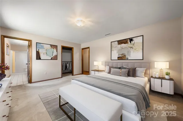 a bedroom with a large bed a painting on the wall and table