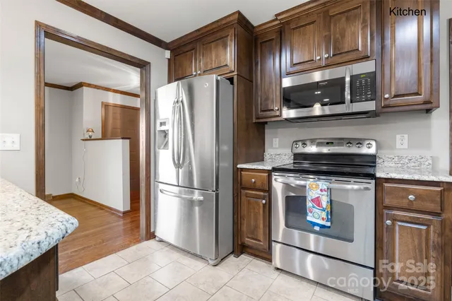 a kitchen with stainless steel appliances granite countertop a refrigerator stove and microwave