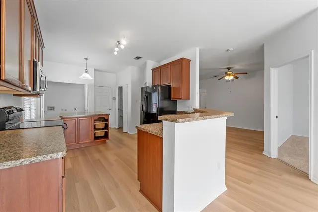 a kitchen with kitchen island a counter top space a sink stainless steel appliances and cabinets