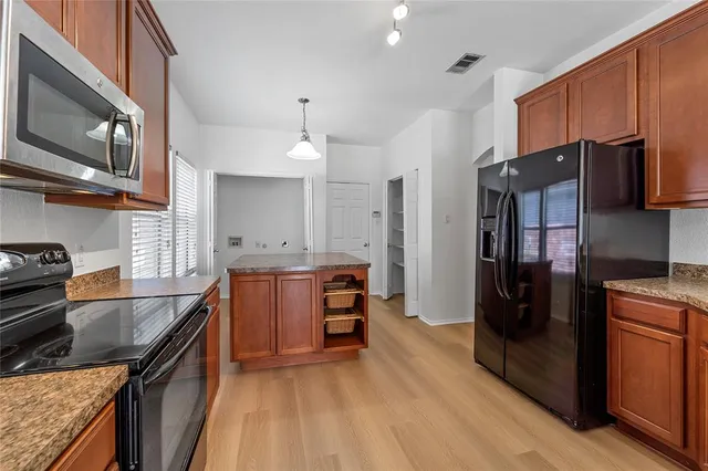 a kitchen with stainless steel appliances granite countertop a refrigerator a stove top oven a sink and dishwasher