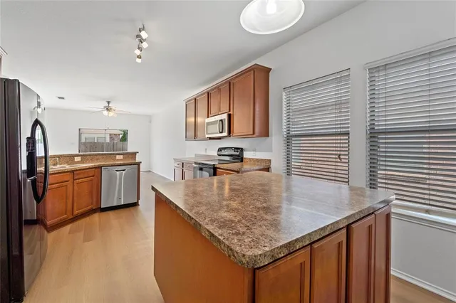 a kitchen with stainless steel appliances granite countertop a sink a stove and refrigerator