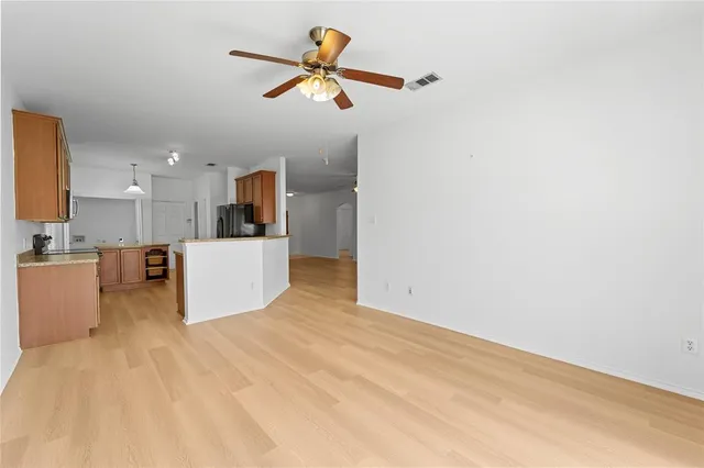 a view of a kitchen with wooden floor and a ceiling fan