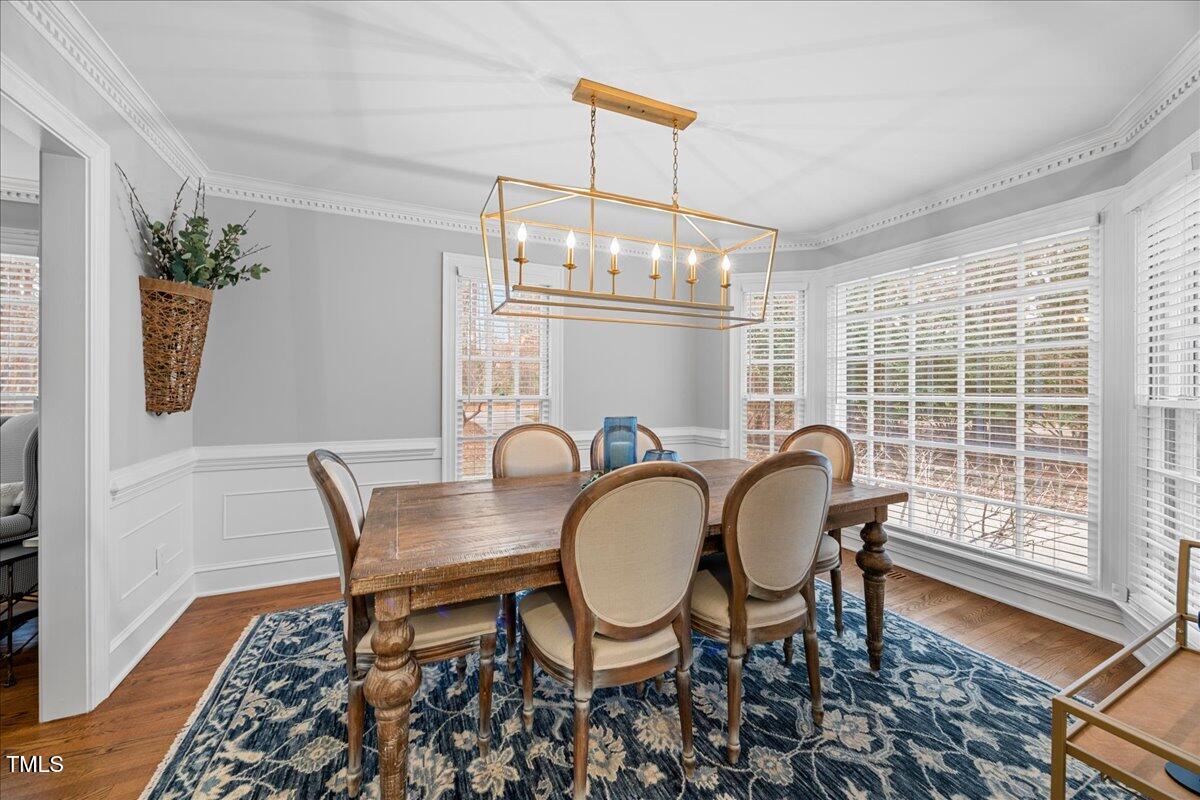 2104 Millpine Drive Raleigh, NC 27614 - Photo 7 of 66 a dining room with furniture a chandelier and wooden floor