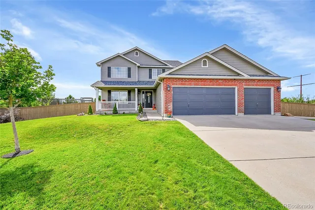 a front view of a house with yard and green space
