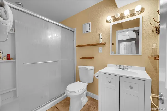 a bathroom with a sink toilet vanity and shower