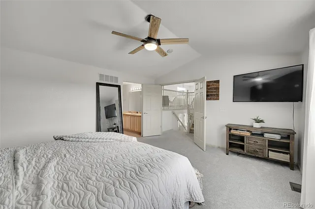 a bedroom with a bed and a flat tv screen on dresser