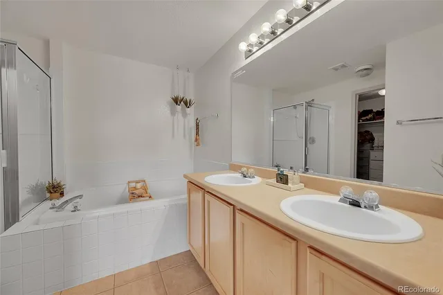a bathroom with a sink double vanity granite tub and a mirror