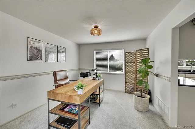a work room with furniture and a potted plant
