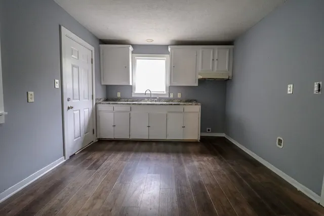 a kitchen with sink cabinets and wooden floor