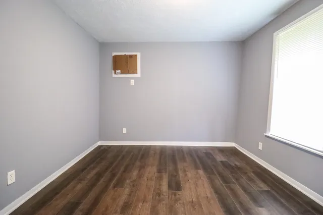 a view of a room with wooden floor and window