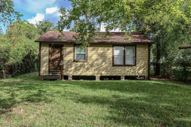a view of a wooden house with a yard