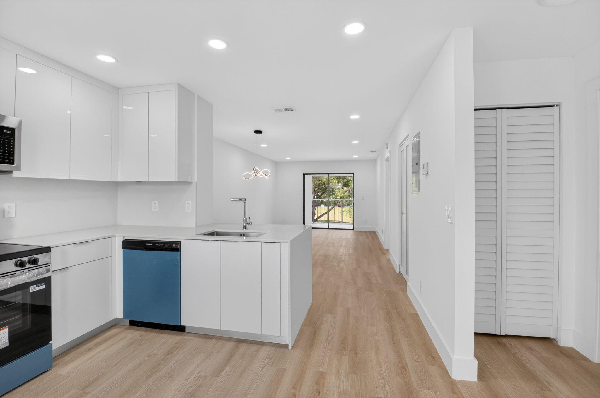 a large kitchen with stainless steel appliances granite countertop a stove and a wooden floors