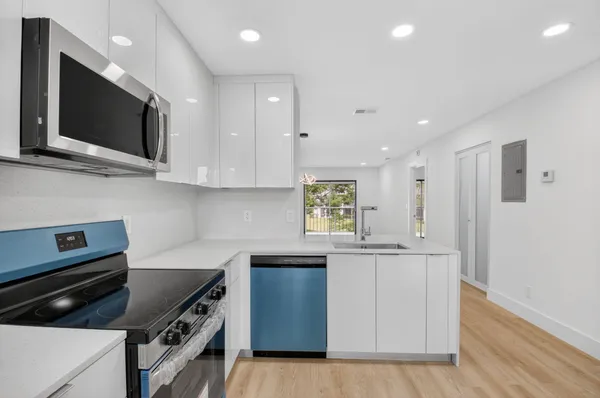 a kitchen with stainless steel appliances a stove microwave and sink