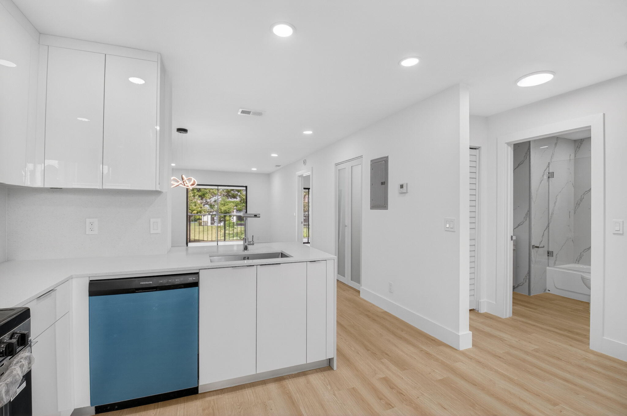 300 West Hidden Valley Boulevard, Unit 308 Boca Raton, FL 33487 - Photo 7 of 39 a kitchen with white cabinets and wooden floor