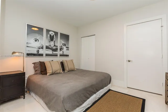 a bedroom with a bed and painting on the wall