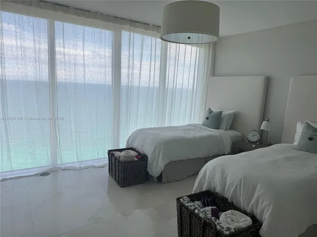 a living room with stainless steel appliances kitchen island a stove a sink dishwasher and white cabinets
