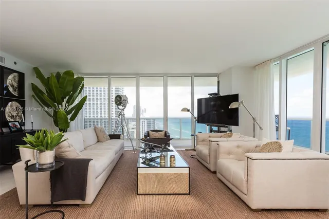a kitchen with a table a chandelier and living room view