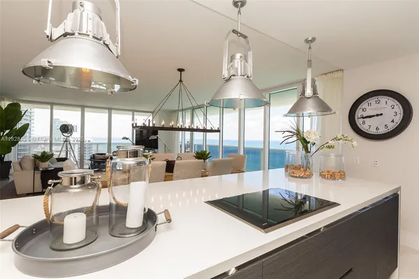 a living room with furniture a chandelier and a dining table